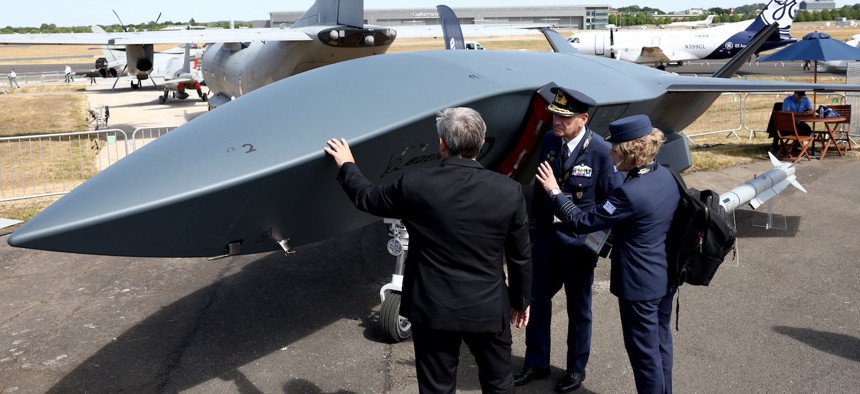 Members of the Greek air force look at the Boeing MQ-28 Ghost Bat on the opening day of the Farnborough International Airshow, July 20, 2026. 