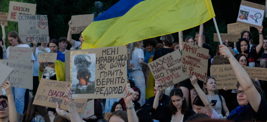 Protesters hold placards and chant slogans during a demonstration against Ukraine's President Volodymyr Zelensky's decision to dismiss Ukraine's Defence Minister Mykhailo Fedorov, in Kyiv on July 17, 2026.
