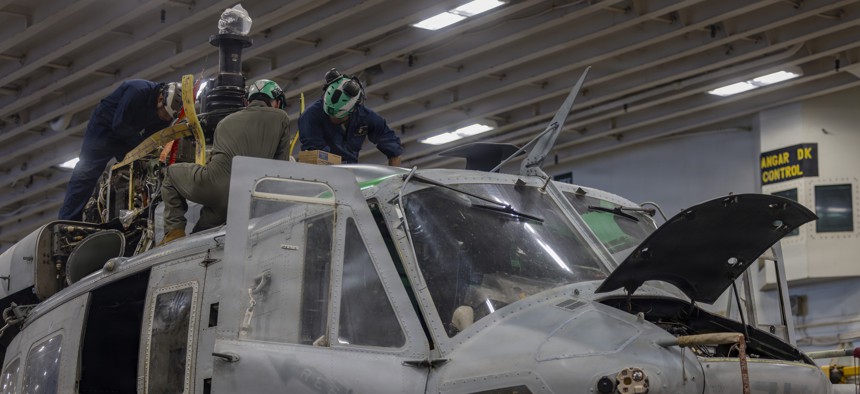 U.S. Marines conduct maintenance on a UH-1Y Venom helicopter aboard the Wasp-class amphibious assault ship USS Essex in the Pacific Ocean, Aug. 8, 2026.