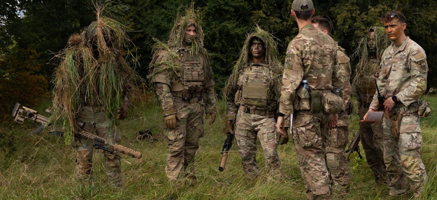 U.S. soldiers with the 37th Armored Regiment and a British Army soldier participate in a concealment and target acquisition exercise at the Bemowo Piskie Training Area in Poland on Aug. 20, 2026.