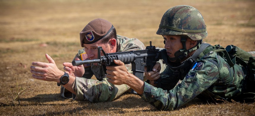 A member of the U.S. Army's 5th Security Force Assistance Brigade instructs a soldier with the 112th Royal Thai Army Striker Battalion on Jan. 15, 2023, in Ko Chan, Thailand.
