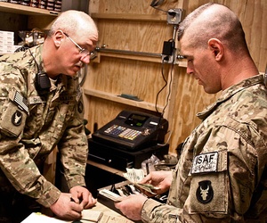 Two soldiers count sales at a new post exchange at Forward Operating Base Mehtar Two soldiers count sales at a new post exchange at Forward Operating Base Mehtar