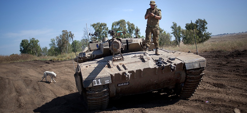 An Israeli soldier on top of a tank in the Golan Heights