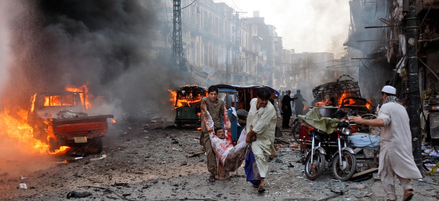 Men carry out victims from a car bomb attack in Peshawar, Pakistan