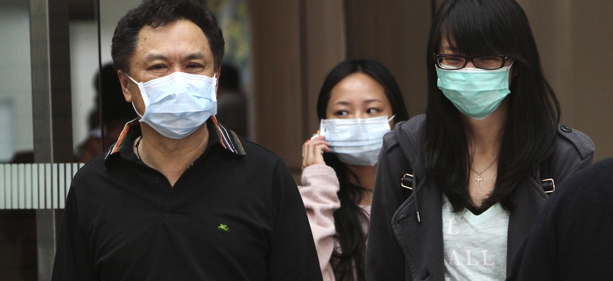 People cover up to protect from bird flu in Taipei, Taiwan, Friday, Apr. 26, 2013.