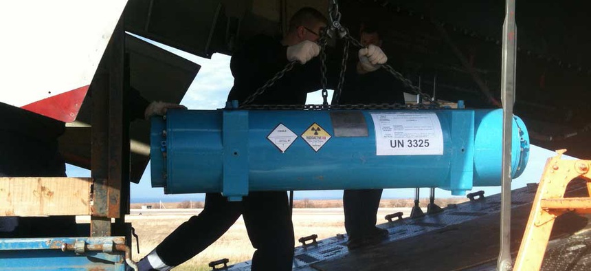 An NNSA employee loading a cask of HEU onto a cargo plane