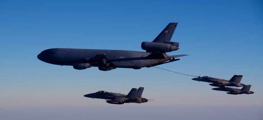 A KC-10A tanker refuels one of the Navy's F/A 18 fighter jets