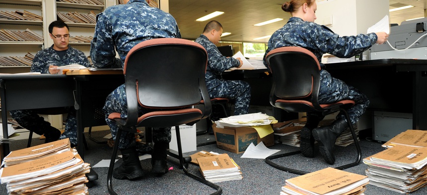 Navy personnel specialists convert Enlisted Field Service Records to electronic files at the Naval Medical Center San Diego, July 28, 2010. 