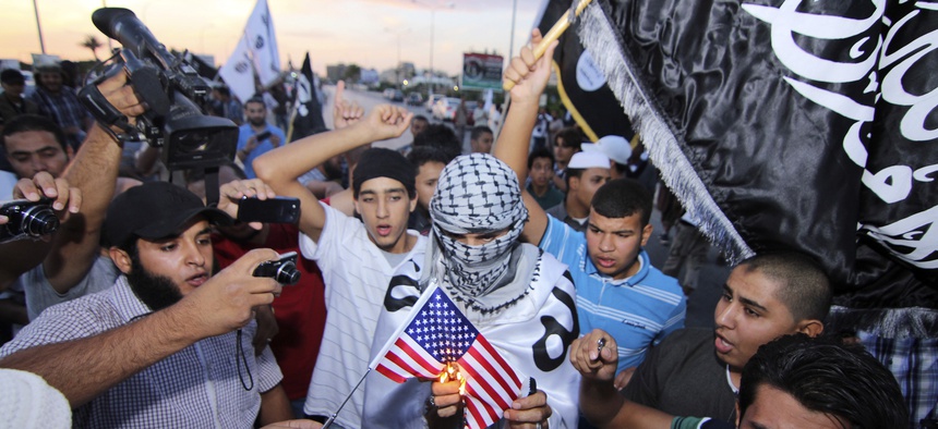 Supporters of the al-Qaeda-linked militant group Ansar al-Shariah burn an American flag in Benghazi, Libya in October.