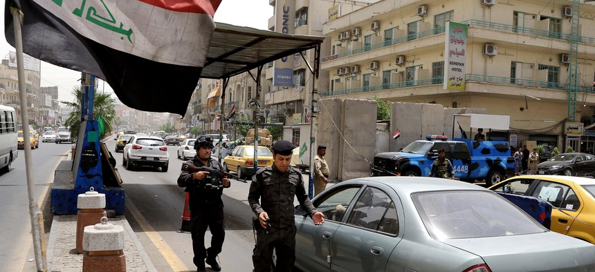 Iraqi federal policemen stand guard at a checkpoint in Baghdad on Wednesday.