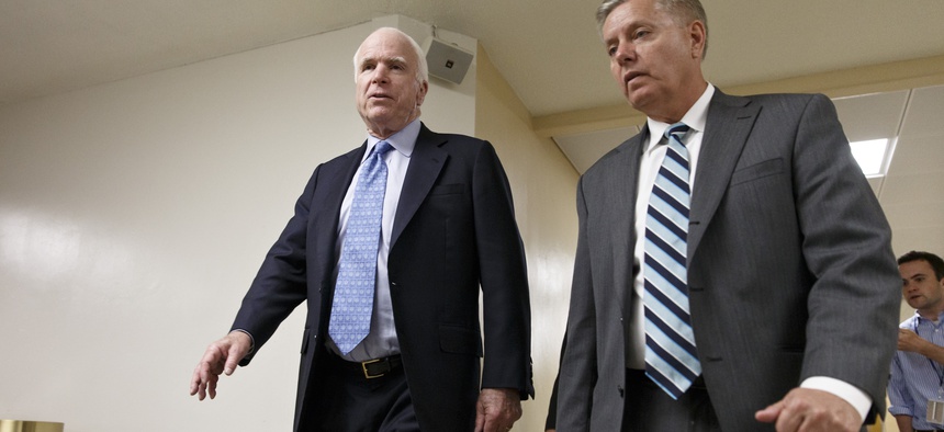 Sens. John McCain, R-Ariz., and Lindsey Graham, R-S.C., leave the Senate after a series of votes, on June 3, 2014.