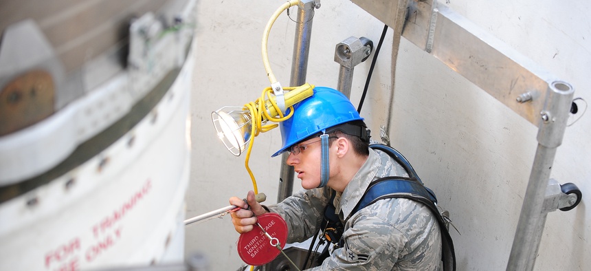 An airman at Minot Air Force Base inspects one of the components on a Minuteman III missile, on April 11, 2013.