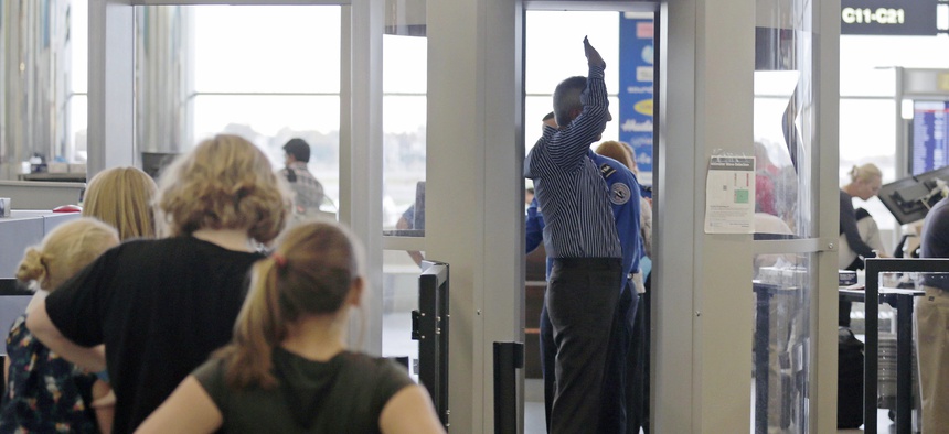 Passengers are scanned by TSA officers at a security checkpoint at Logan Airport in Boston, on October 24, 2012.