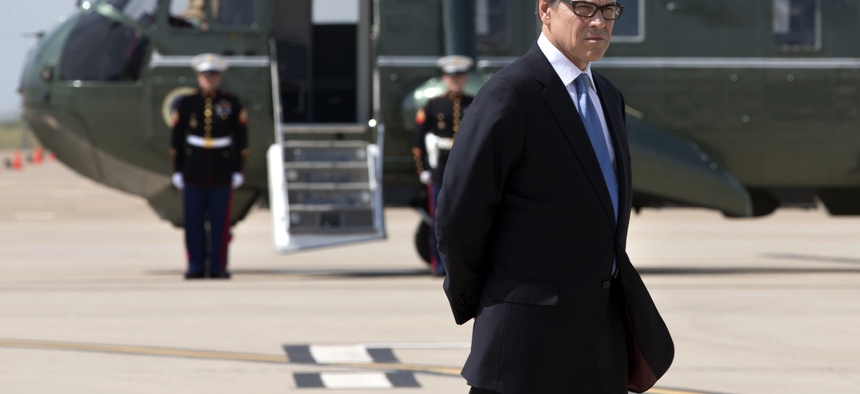 Texas Gov. Rick Perry waits to meet President Obama on the tarmac in Dallas prior to a meeting, on July 9, 2014.