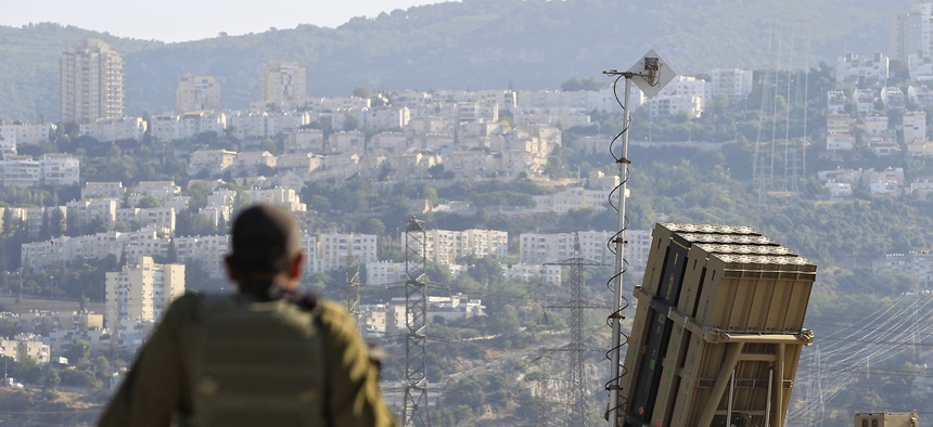 An Israeli soldier sits next to an Iron Dome rocket interceptor deployed near Haifa, on August 28, 2013.