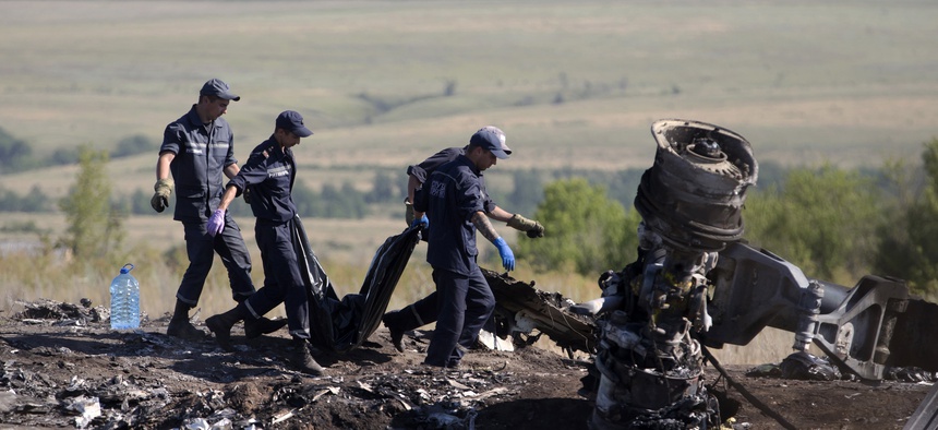 Ukrainian emergency workers on Monday carry a victim's body in a plastic bag at the crash site of Malaysia Airlines Flight 17.