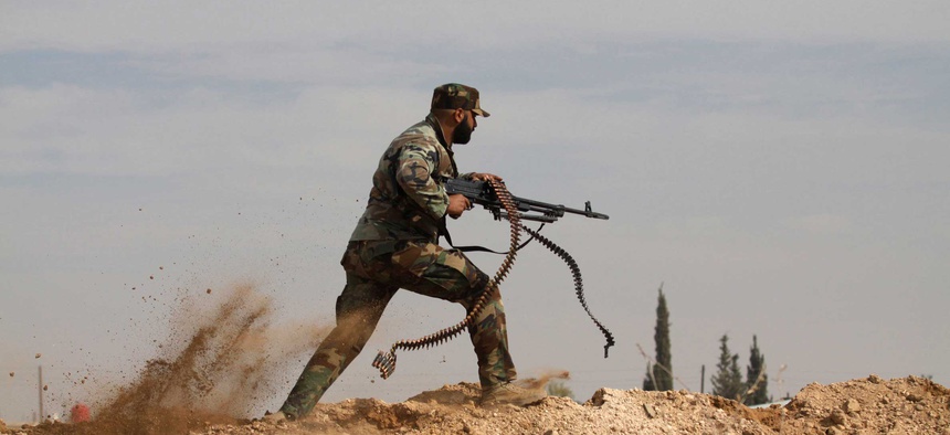 An Iraqi Shiite fighter clashes with members of the Sunni Free Syrian Army in Hatita, on November 22, 2013.