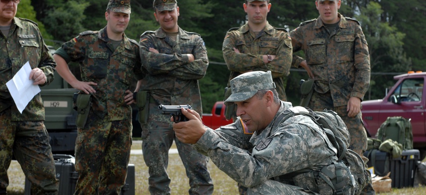 A sergeant with the 200th Military Police Command trains German soldiers during a 9mm marksmanship training course.