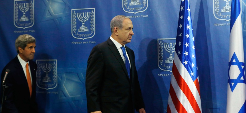 Israeli Prime Minister Benjamin Netanyahu walks on stage with Secretary of State John Kerry for a photo opportunity before a meeting in Tel Aviv on July 23, 2014.
