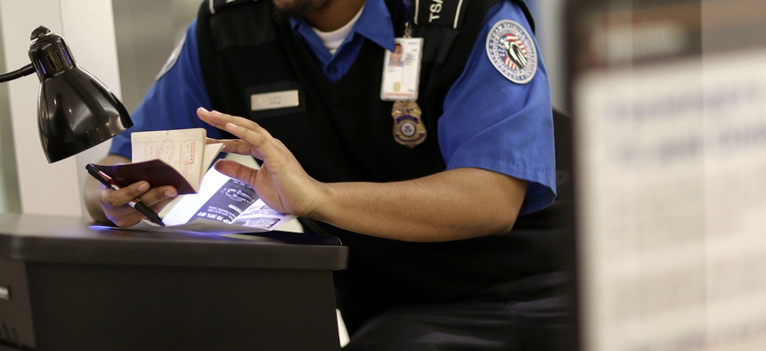 A TSA official checks a passport at a checkpoint at Baltimore-Washington International Airport in Linthicum, Md.