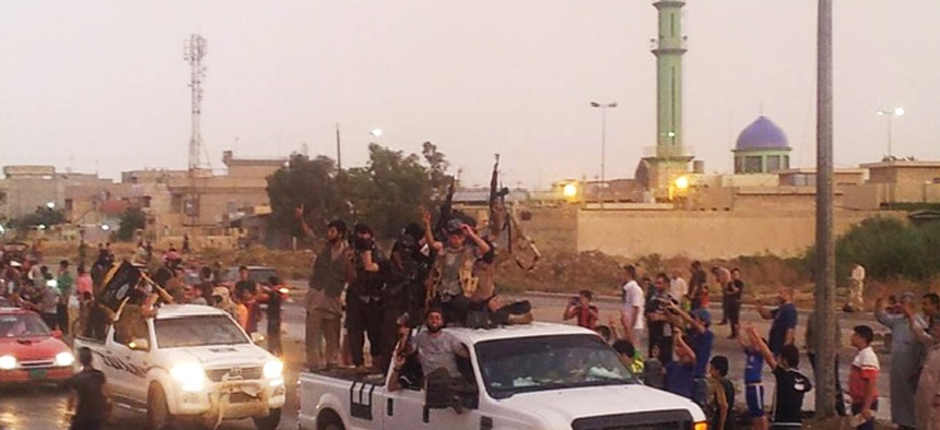 Militants with the Islamic State of Iraq and the Levant parade in the northern city of Mosul, Iraq, on June 25, 2014.