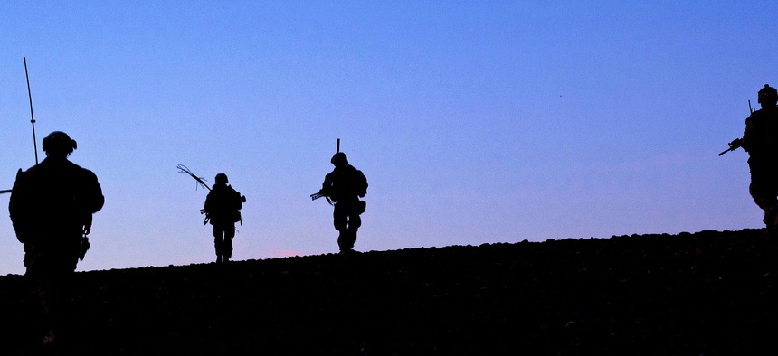 Marines with the 9th Marine Regiment crest a hill at the end of a patrol through Helmand province, Afghanistan.