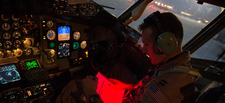U.S. Air Force Capt. Trent Parker, 340th Expeditionary Air Refueling Squadron, KC-135 Stratotanker pilot, reads a pre-flight checklist prior to an in-air refueling mission over Iraq, Aug. 12, 2014.