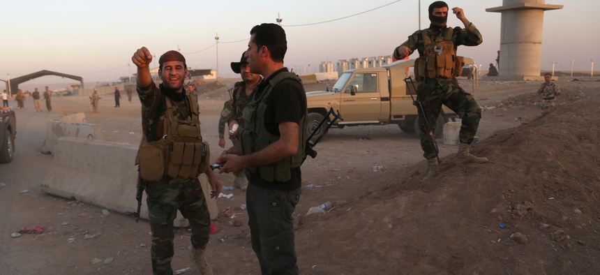 Kurdish Peshmerga fighters react during airstrikes target Islamic State militants near the Khazer checkpoint outside of Erbil, Iraq.