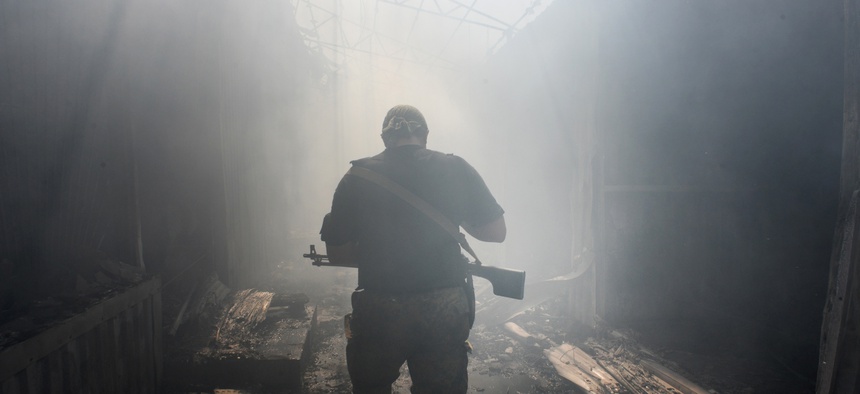A Pro-Russian rebel walks in a passage at the local market damaged by shelling in Petrovskiy district in the town of Donetsk, eastern Ukraine, Aug. 26, 2014.