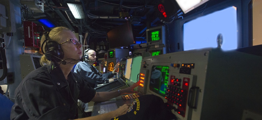 The commanding officer of the USS Arleigh Burke observes operations in the combat information center.
