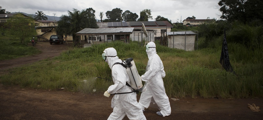Healthcare workers in Sierra Leone spray disinfectant to prevent the spread of the Ebola virus in Kenema, on September 24, 2014.