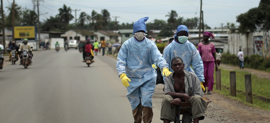 Residents of the St. Paul Bridget neighborhood take a man suspected of carrying the Ebola virus to a clinic, in Monrovia, Liberia.