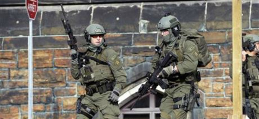 A Royal Canadian Mounted Police intervention team responds to a reported shooting at Parliament building in Ottawa, Wednesday, Oct. 22, 2014.