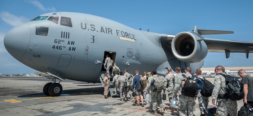 A group of 30 U.S. military personnel, including Marines, Airmen, and Soldiers from the 101st Airborne Division, board a C-17 in Senegal en route to Liberia.