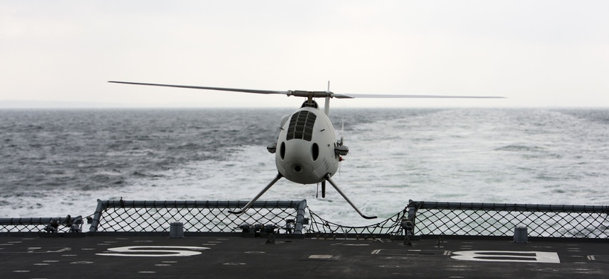 A Schiebel Camcopter S-100 drone hovers during a test aboard a ship.