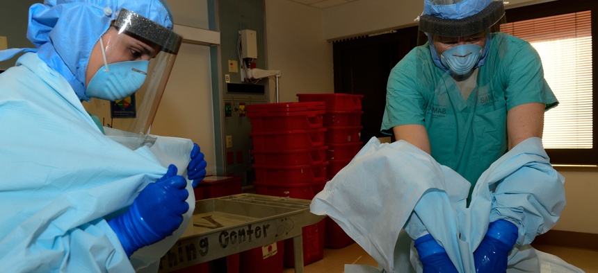 Two Army officers take off their protective personal equipment while training for Ebola response operations at the San Antonio Military Medical Center, on October 23, 2014.