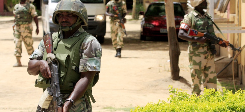 Nigerian soldiers stand guard at the offices of the state-run Nigerian Television Authority in Maiduguri, Nigeria.