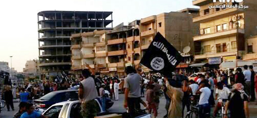 This file photo posted by the Raqqa Media Center, a Syrian opposition group, on Monday, June 30, 2014, which has been verified and is consistent with other AP reporting, shows fighters from extremist Islamic State group during a parade in Raqqa, Syria.