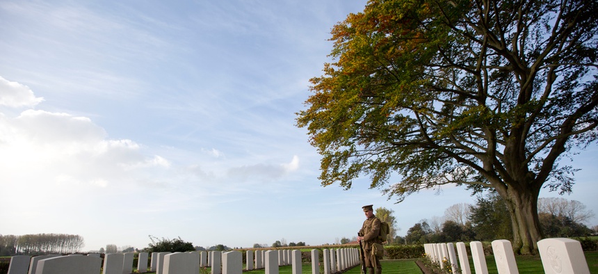 Re-enactor Chris Barker looks at gravestones during a re-burial ceremony for 15 World War I soldiers in Bois-Grenier, France, Oct. 22, 2014. Fifteen British WWI soldiers were re-buried at Y Farm Commonwealth cemetery nearly a century after they perished.