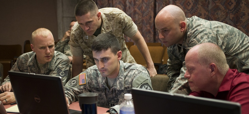 A Naval Academy professor works with his teammates at the Army's Cyber Center of Excellence at Fort Gordon during "NetWar," on June 10, 2014.