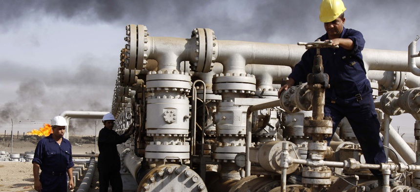 Iraqi laborers work at the Rumaila oil refinery near the city of Basra, Iraq, on December 13, 2009.