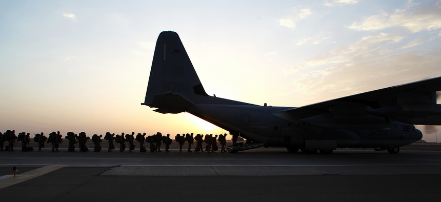 Troops with the Marine Expeditionary Brigade load onto a KC-130 aircraft onto the Camp Bastion flightline, on October 27, 2014.