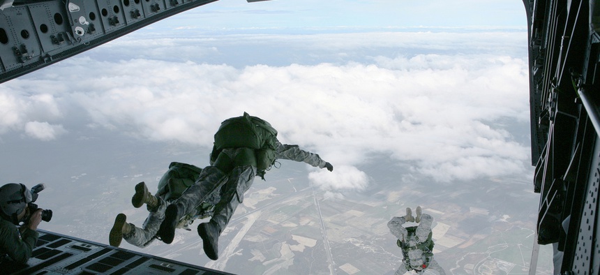 Members of the U.S. Army Special Forces soar out of the back of a C-17 during a HALO training exercise.