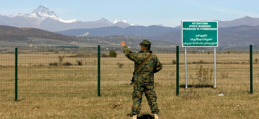 A Georgian police officer guards the border with the breakaway province of South Ossetia, near the village of Dvani, on October 22, 2013.