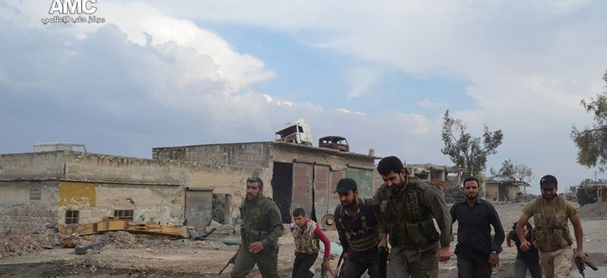 Members of the Free Syrian Army run at the front lines in the town of Sheikh Najjar, in Aleppo, Syria, on June 10, 2014.