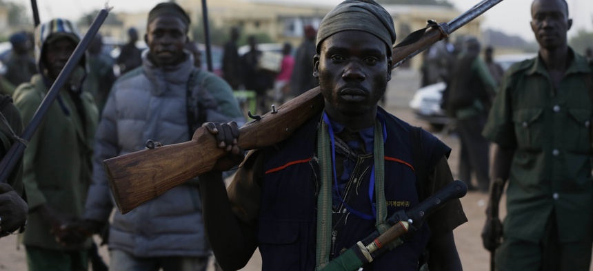 Vigilantes and local hunters armed with locally made guns gather before they go on patrol in Yola, Nigeria, Wednesday, Nov. 25, 2014.