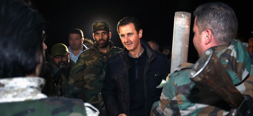 Syrian President Bashar al Assad speaks with troops on the front lines in Damascus, Syria, on January 1, 2015.