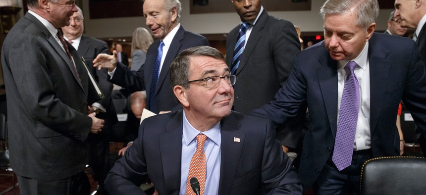 Ashton Carter, President Obama's nominee to become secretary of defense, is greeted by Sen. Lindsey Graham, R-S.C., during a break in testimony, on February 4, 2015.