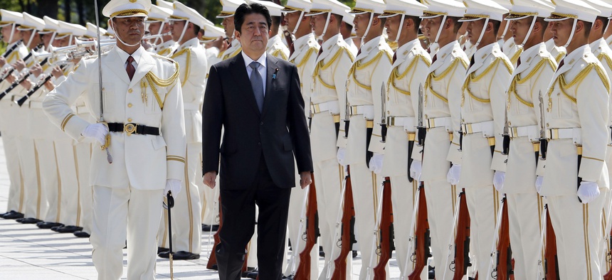 Japanese Prime Minister Shinzo Abe reviews an honor guard in a ceremony prior to his meeting with officers of the Japan Self Defense Forces, on Sept. 12, 2013.