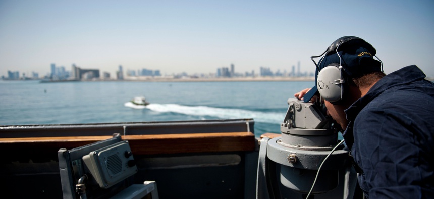 A U.S. sailor tracks passing landmarks as the guided-missile destroyer USS Arleigh Burke (DDG 51) arrives in Abu Dhabi, United Arab Emirates for a regularly scheduled port visit, April 26, 2014.